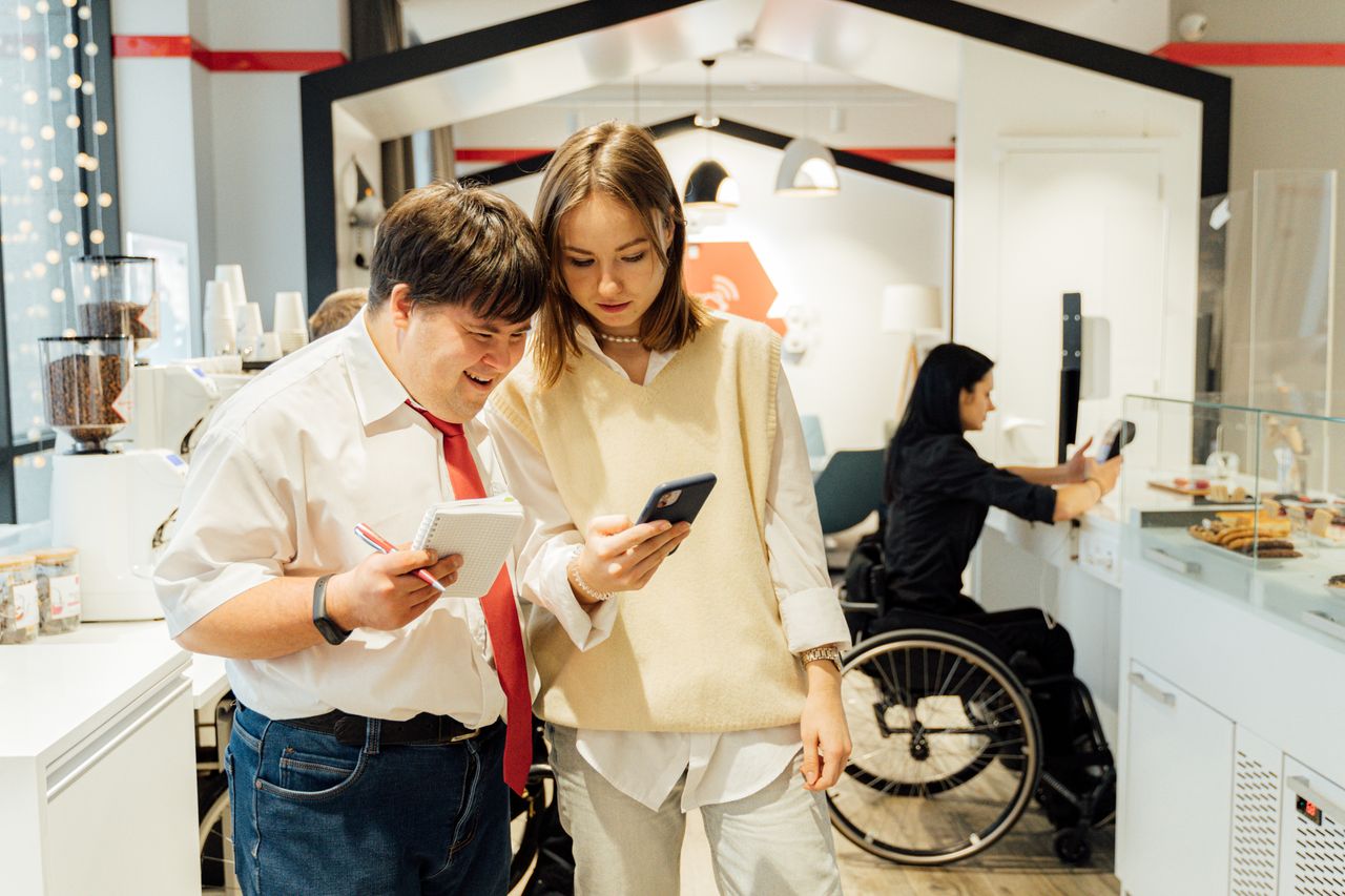 A diverse group in a coffee shop shows inclusivity and accessibility with attentive customer service.